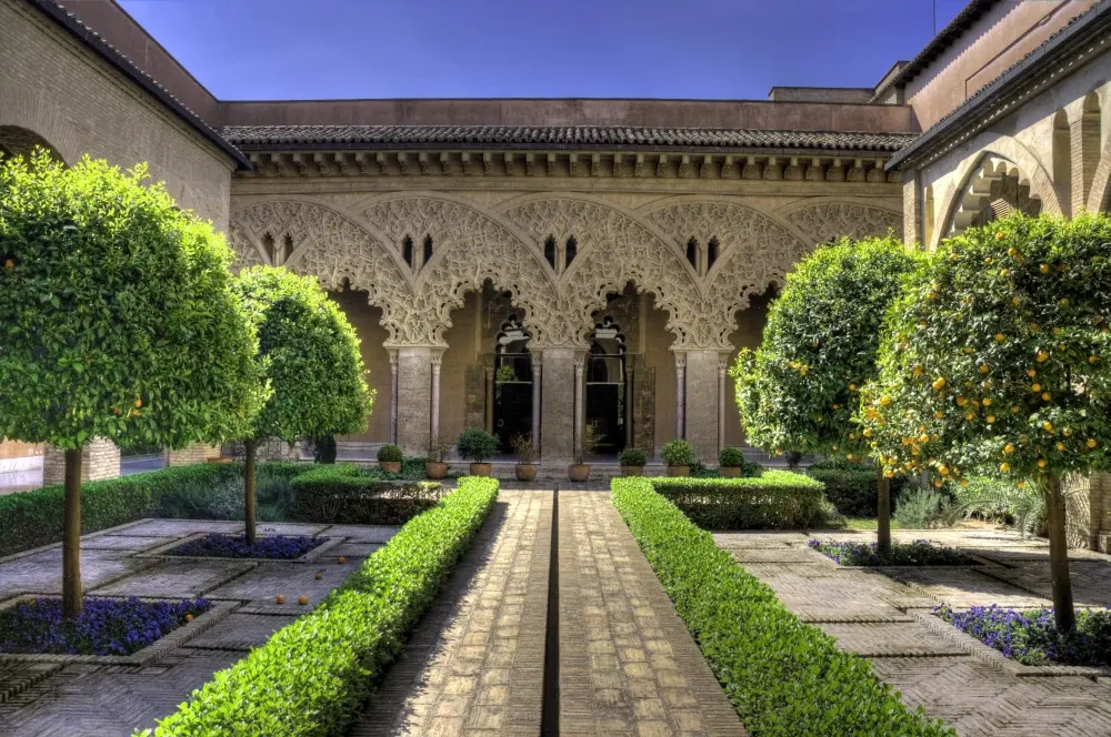 The courtyard of the Aljafería Palace in Zaragoza with its intricate Islamic arches.