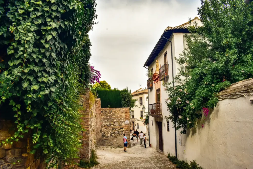 Narrow street and walls in the historic Albayzín district, Granada, showing preserved Muslim heritage and architecture.