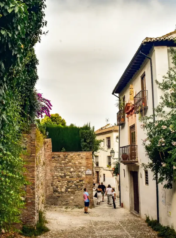 Narrow street and walls in the historic Albayzín district, Granada, showing preserved Muslim heritage and architecture.