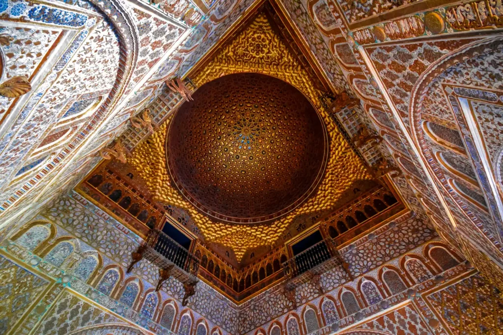 Intricate geometric dome and ceiling architecture inside the Royal Alcázar of Seville, a stunning Islamic palace.