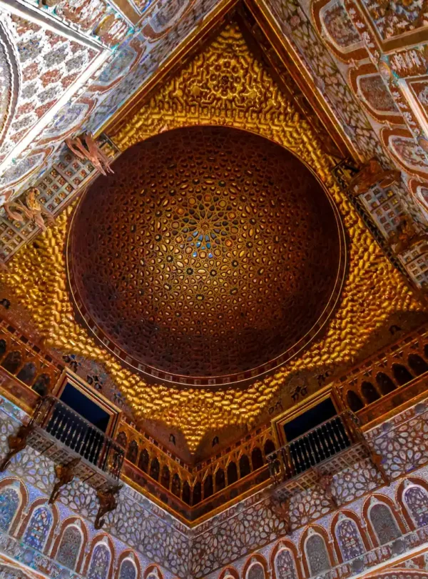 Intricate geometric dome and ceiling architecture inside the Royal Alcázar of Seville, a stunning Islamic palace.