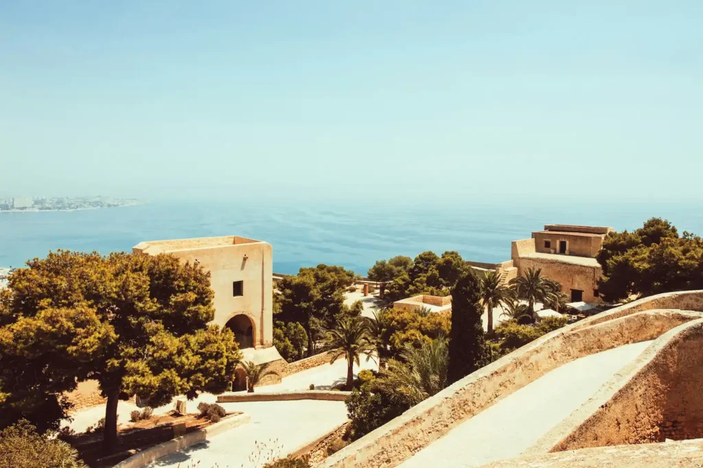 Coastal view of Málaga with the historic Alcazaba fortress walls on the hill, representing significant Islamic heritage in Andalusia.
