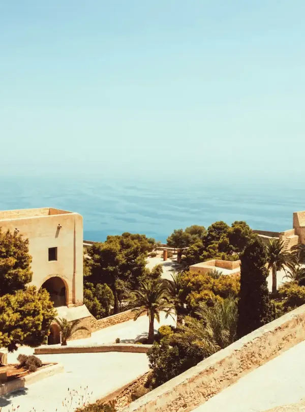 Coastal view of Málaga with the historic Alcazaba fortress walls on the hill, representing significant Islamic heritage in Andalusia.